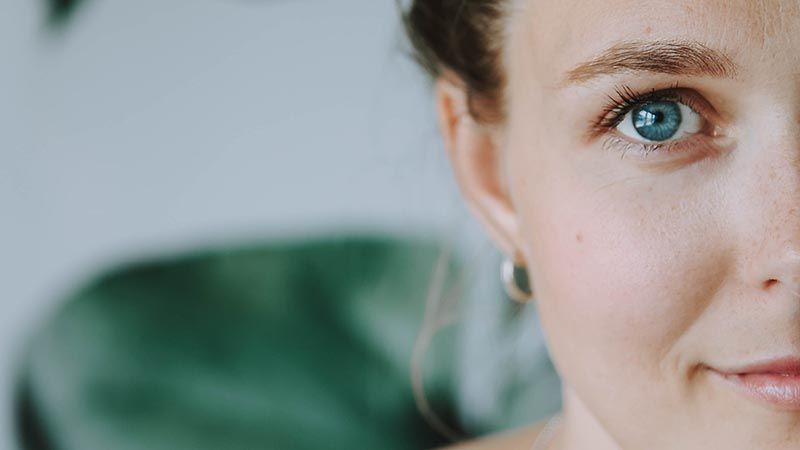 kvinna med blåa ögon tittar in i kameran
