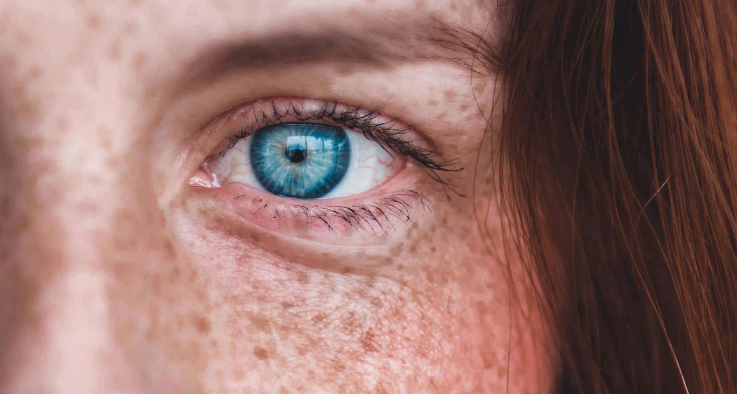 Blåa ögon och ansikte med fräknar